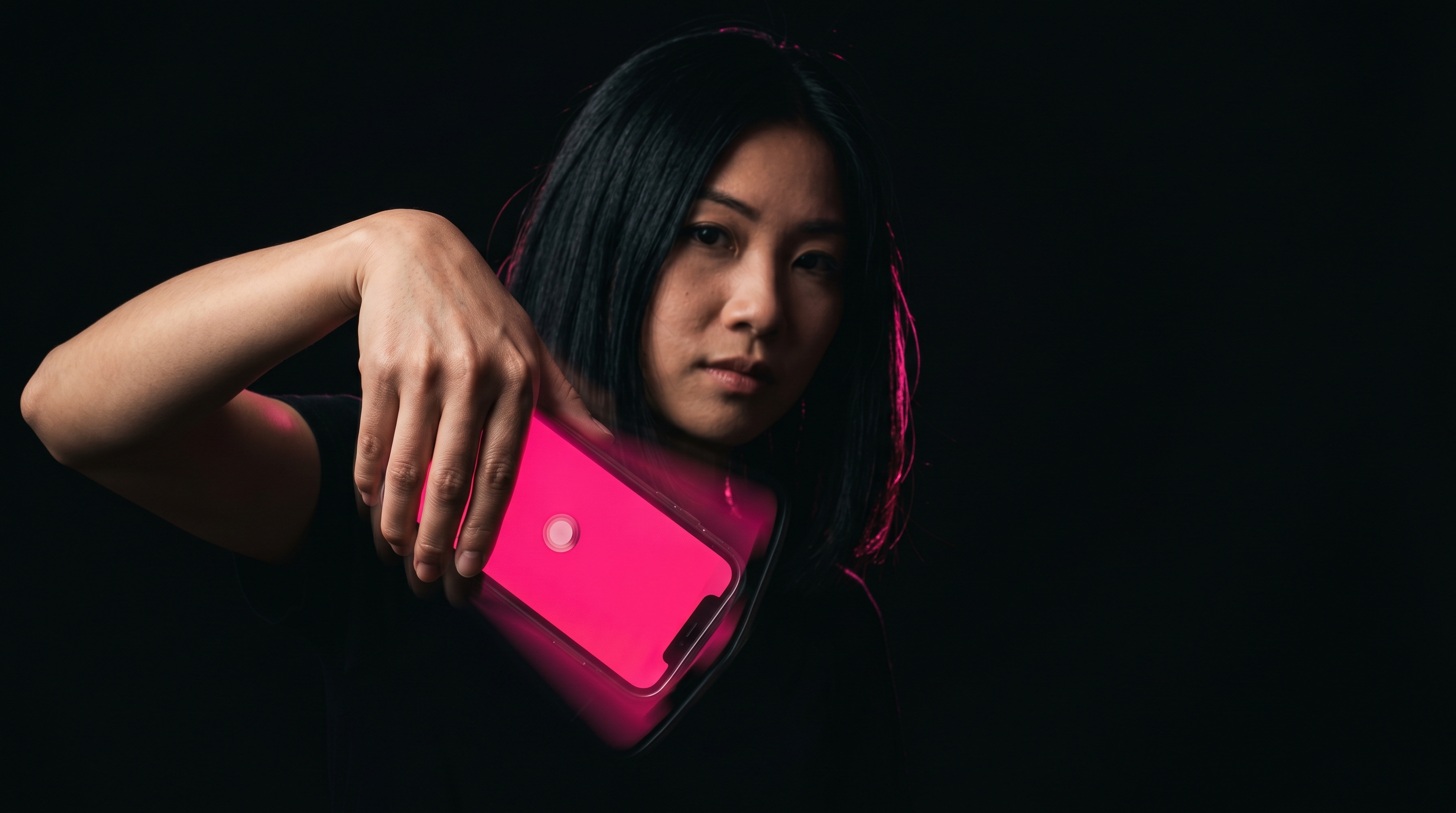 Vietnamese woman mid-shake with smartphone glowing pink, motion blur on the wrist
